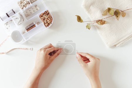 Photo for Blank copy space with sewing tools: buttons, spool, thimble, tape-measure, needles on white background. Flat lay, top view. Hobby, leisure concept. - Royalty Free Image