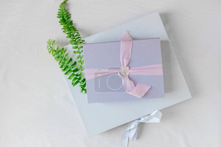 Téléchargez les photos : Coffrets cadeaux ou cadeaux et feuilles de fougère sur fond blanc - en image libre de droit