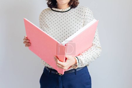 Téléchargez les photos : Plan recadré d'une jeune femme tenant un catalogue rose - en image libre de droit