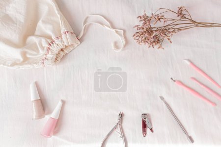 Foto de Composición con esmalte de uñas, bolsa de algodón y herramientas de manicura. Blog de belleza, concepto de manicura. - Imagen libre de derechos