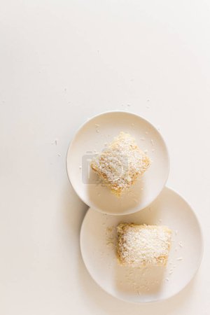 Foto de Delicioso pastel de coco en platos blancos sobre fondo blanco - Imagen libre de derechos