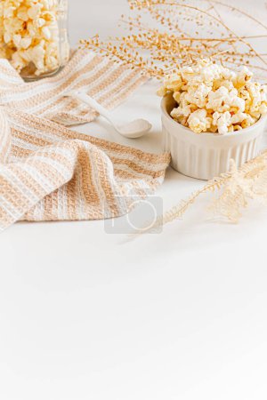 Foto de Composición estética con palomitas de maíz en tazones blancos sobre fondo blanco. Otoño, concepto de comida de invierno. - Imagen libre de derechos