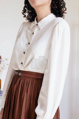 Téléchargez les photos : Jeune jolie femme en jupe plissée, chemise blanche sur fond blanc. Mode vintage inspiré look vêtements. - en image libre de droit