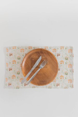 Photo for Top view of wooden plate with fork and knife on the top - Royalty Free Image