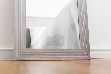 Photo for Cozy light room interior. Cropped shot of bed reflection in the mirror. - Royalty Free Image