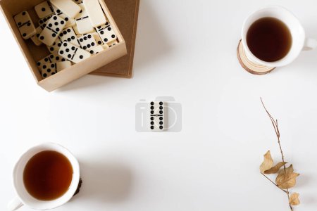 Téléchargez les photos : Domino vintage et deux tasses de thé sur fond blanc. - en image libre de droit