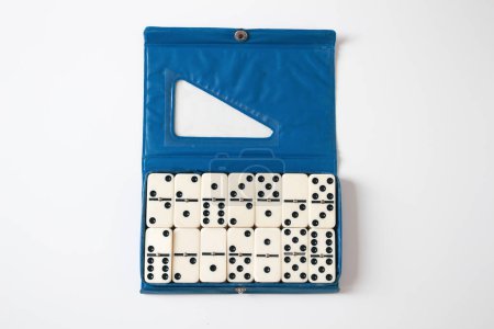 Téléchargez les photos : Vintage domino en boîte bleue ouverte sur fond blanc. - en image libre de droit