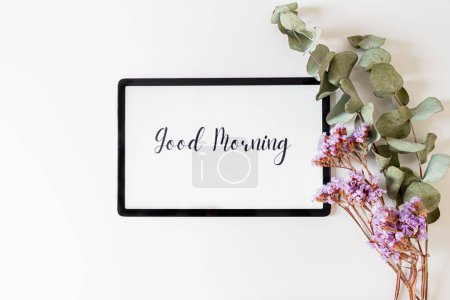 Téléchargez les photos : Cadre avec branches florales sèches et fraîches isolé et phrase Bonjour sur écran de table numérique sur fond blanc. - en image libre de droit