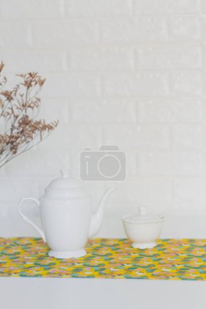 Téléchargez les photos : Concept d'heure du thé. Théière avec sucre et fleurs séchées en vase sur la table. - en image libre de droit