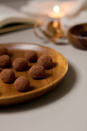 Photo for Delicious dessert concept.  Closeup view of chocolate truffles covered with cocoa powder on wooden plate. - Royalty Free Image