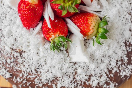 Téléchargez les photos : Gâteau au chocolat, noix de coco et fraise sur fond. - en image libre de droit
