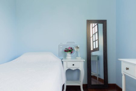 Foto de Reflejo de cama en el espejo. Diseño clásico femenino moderno en colores azules. Cómodo interior del hogar. - Imagen libre de derechos