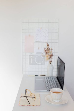 Photo for Business concept. Minimalist home office desk with laptop, cup of tea and stationary supplies - Royalty Free Image
