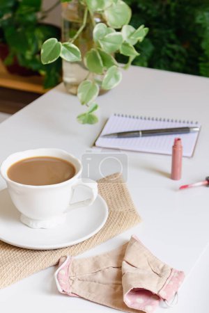 Téléchargez les photos : Tasse de café avec lait, cahier, stylo et rouge à lèvres sur table blanche. Concept de café. - en image libre de droit