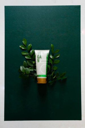 Photo for Vegan cosmetic cream with green leaves isolated on deep green background. Skin care concept. - Royalty Free Image