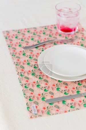 Téléchargez les photos : Boisson à la groseille avec glaçons en verre et ustensiles de cuisine vides servis sur nappe colorée - en image libre de droit