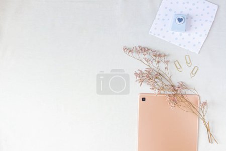 Photo for Flat lay of rose gold tablet with cozy space mock up. Top view home office desk workspace decorated with dried flower branches and stationery supplies. - Royalty Free Image