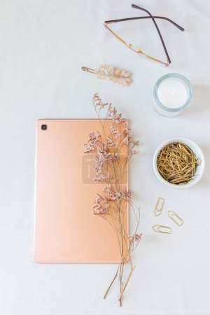 Photo for Top view of digital tablet with lilac flowers, paper clips on white - Royalty Free Image