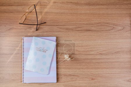 Photo for Work at home concept. aesthetic minimalist workspace with notebooks, glasses and dried flowers. - Royalty Free Image