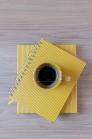 Téléchargez les photos : Vue du dessus de tasse de café sur le dessus des planificateurs jaunes sur la table en bois - en image libre de droit