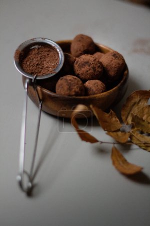 Téléchargez les photos : Bol en bois de truffes au chocolat recouvert de cacao en poudre. Délicieux dessert concept. - en image libre de droit
