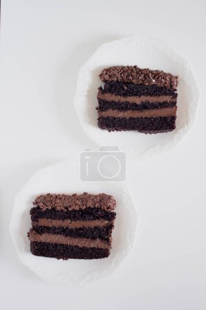 Téléchargez les photos : Deux assiettes avec des pièces de gâteau au chocolat décorées sur fond blanc. Confort de fête concept alimentaire. - en image libre de droit