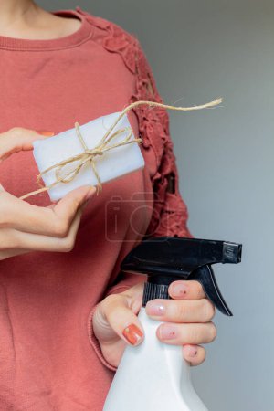 Foto de Una mujer sostiene un regalo con una cinta en la mano, sobre un fondo gris. el concepto de un regalo, Navidad y vacaciones de año nuevo. - Imagen libre de derechos