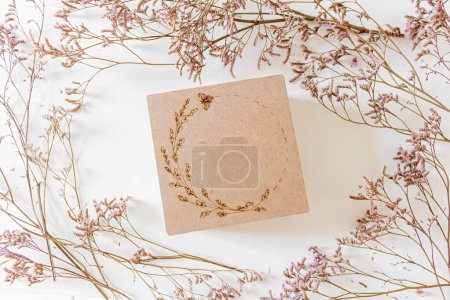 Photo for Round frame with lilac flowers and craft paper gift box. Flat lay, top view. - Royalty Free Image