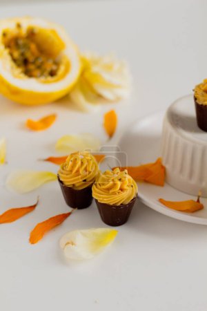 Foto de Composición estética con cupcakes, maracuyá y pétalos florales alrededor - Imagen libre de derechos