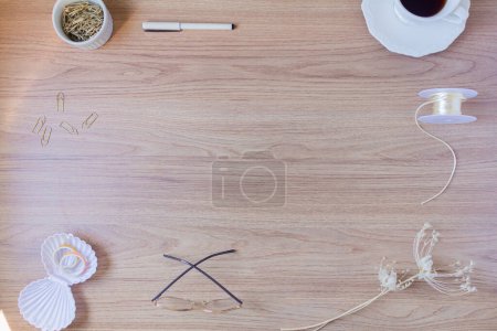 Foto de Marco hecho de taza de café, pluma, clips de papel, vasos, cuerdas y flores secas sobre fondo de madera. - Imagen libre de derechos