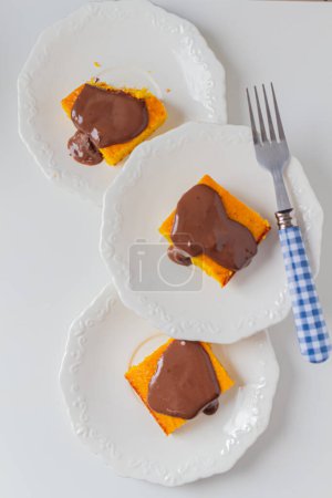 Foto de Vista superior de tres platos con pasteles de zanahoria brasileña sobre fondo blanco - Receta de la madre - Imagen libre de derechos