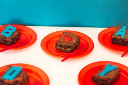 Téléchargez les photos : Des tranches de brownies sur des assiettes rouges. Concept de style alimentaire moderne. - en image libre de droit