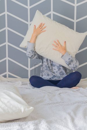 Téléchargez les photos : Plan recadré d'une jeune femme tenant un oreiller dans sa chambre - en image libre de droit