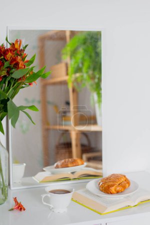 Téléchargez les photos : Petit déjeuner matinal avec croissants sur livres ouverts et tasses de thé - en image libre de droit