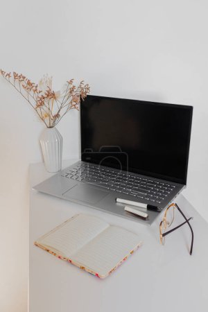 Photo for Home office desk workspace on white desk with laptop, notebook and eyeglasses - Royalty Free Image