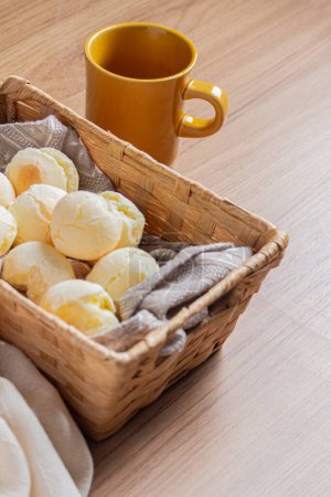Téléchargez les photos : Composition petit déjeuner brésilien avec panier de paille plein de pain au fromage avec tasse de café - en image libre de droit