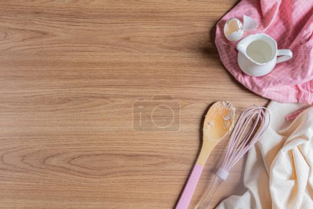Foto de Concepto de Receta Brasileña Casera. Utensilios de cocina con jarra de leche y cáscaras de huevo en la servilleta de cocina con fondo de madera - Imagen libre de derechos