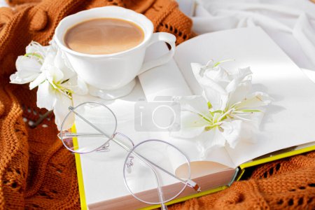 Photo for Slow morning composition. Book, coffee with milk, flowers, glasses on a messy bed. Fall, autumn concept. - Royalty Free Image