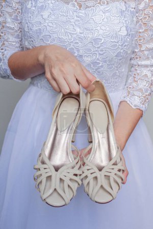 Foto de Joven y bonita novia sosteniendo zapatos - Imagen libre de derechos