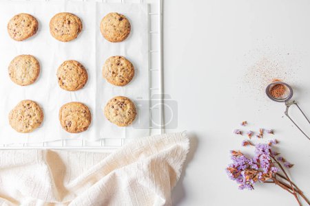 Téléchargez les photos : Délicieux biscuits faits à la main sur fond blanc avec du tissu de lin et des fleurs autour - en image libre de droit