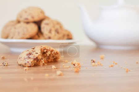 Téléchargez les photos : Délicieux biscuits dans une assiette en céramique avec théière sur une table en bois - en image libre de droit