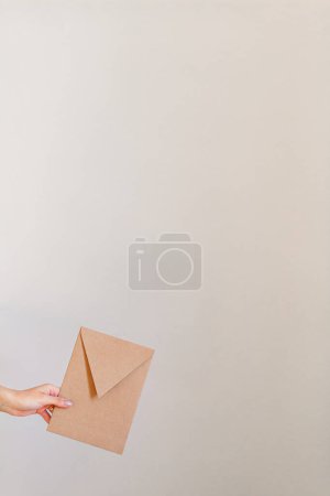 Photo for Female hand holding brown envelope - Royalty Free Image