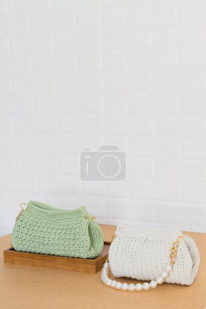 Téléchargez les photos : Vert et blanc sacs à main crochet femelle sur fond beige. Concept de mode - en image libre de droit