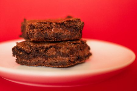 Téléchargez les photos : Brownie sur fond rouge. Composition de style alimentaire moderne - en image libre de droit