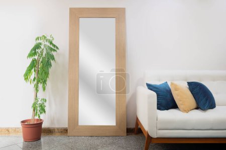 Foto de Cómoda sala de estar con planta de interior y espejo grande. Concepto de decoración escandinava. - Imagen libre de derechos