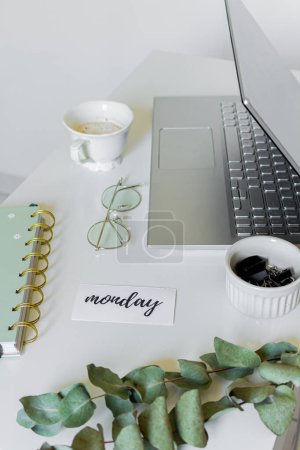 Photo for Home office desk workspace with laptop, notebook, eucalyptus branches, glasses on white table. Flat lay, top view. Minimal feminine mock up. - Royalty Free Image