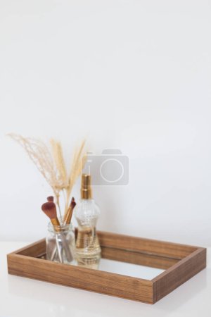 Téléchargez les photos : Brosses de maquillage, vase végétal séché et parfum sur plateau miroir. Composition esthétique minimaliste beige. - en image libre de droit