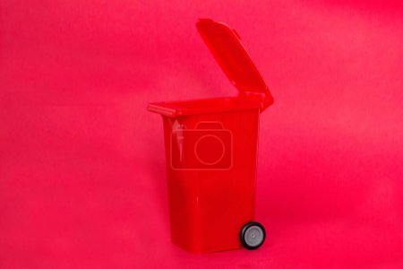 Téléchargez les photos : Poubelle sur fond rouge. Concept de recyclage. - en image libre de droit
