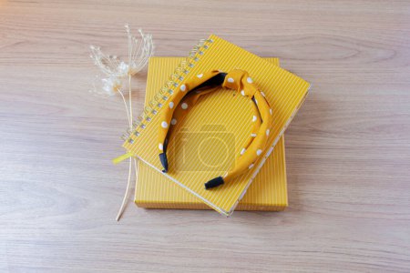 Photo for Home office workspace concept with yellow planners, wild flowers and headband on a wooden table. - Royalty Free Image