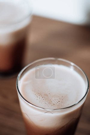Photo for Closeup view of Dalgona coffee with milk on wooden table. - Royalty Free Image